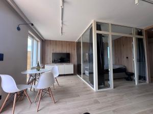 a living room with a table and chairs and a bedroom at Diuna Apartamenty in Rowy
