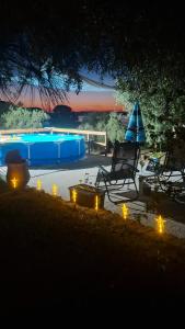 a chair and an umbrella and a pool at night at Dimitra's Villa in Evia, Greece in Loukísia