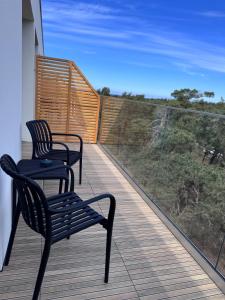 two chairs and a table on a balcony with a view at Diuna Apartamenty in Rowy