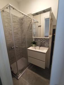 a bathroom with a shower and a sink and a mirror at Mercury Room in Limbiate
