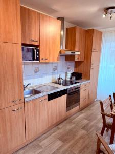 a kitchen with wooden cabinets and a sink at Le Cosy Home in Guebwiller