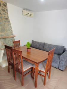 a wooden table with four chairs and a couch at Casa Verde in Lukovë