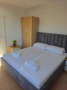 a bedroom with a large bed with two towels on it at Casa Verde in Lukovë