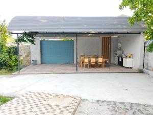a blue garage with a table and chairs on a patio at redHome in Gabala