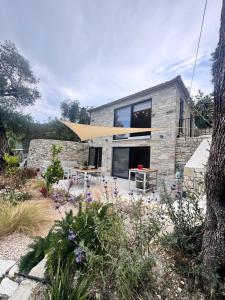 a stone house with a picnic table in front of it at Lucié in Argyrátika