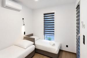 two beds in a room with a window at ECO HOUSE in Szypliszki