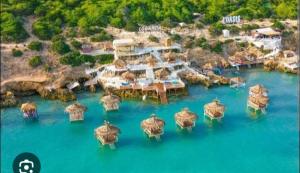 an aerial view of a resort with umbrellas in the water at SecretVilla in Ghār al Milḩ