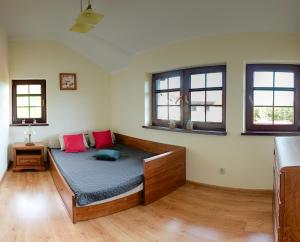 a bed in a room with two windows at Zaciszna Przystań Dębina in Debina