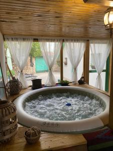 a large bath tub in a room with windows at Vila Agroturizam Kućica Mostar in Mostar +25 photos