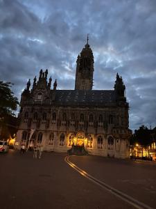 a large building with a clock tower at night at Zeeuws Ontspannen - Privé Wellness & Suites in Middelburg