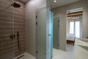 ein Badezimmer mit Dusche mit Glastür in der Unterkunft ARGO Luxury Suites in Milína