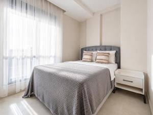 a white bedroom with a large bed with a window at The Orange Cactus in Antalya
