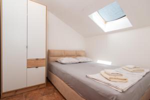 a bedroom with a bed with towels on it at Apartment Veslo in Begovići