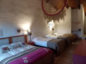 a room with three beds in a room at La Posada de Tafi in Tafí del Valle