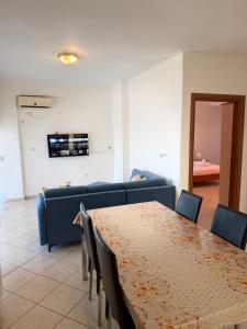 a dining room with a table and a couch at Saranda Port View Apartments in Sarandë