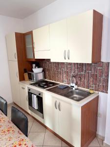 a kitchen with a sink and a stove top oven at Saranda Port View Apartments in Sarandë +4 photos