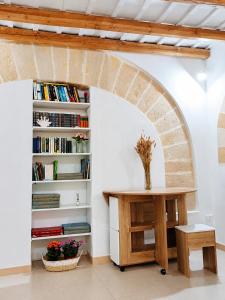 ein Zimmer mit einem Tisch und einem Bücherregal in der Unterkunft Arkea in Trapani