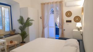 a bedroom with a white bed and a plant at Casa Mare Blu in Imperia
