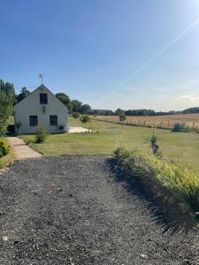 a white house in the middle of a field at Parenthèse au Gué des Archers maison climatisée in Saint-Valérien