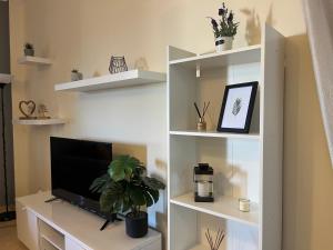 a living room with a tv on a white shelf at Andrew's place in Metogjashta