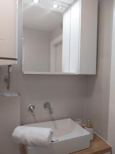 a bathroom with a white sink and a mirror at Mala kuća Divna in Brela