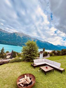 a couch sitting on top of a field with a lake at Chalet Luna - Alpine Apartment by Lake Brienz in Niederried