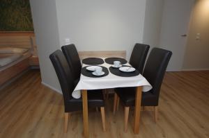 a table with black chairs and a white table cloth at Ferienwohnung Dorada in Neukirch
