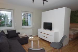 a living room with a couch and a tv at Ferienwohnung Dorada in Neukirch