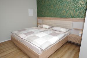 a bedroom with a large bed with a green wall at Ferienwohnung Dorada in Neukirch +7 photos