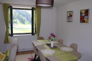 a dining room with a table and a window at Bjelašnica Escape in Bjelašnica