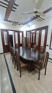 a dining room with a black table and chairs at Classy home in Lahore