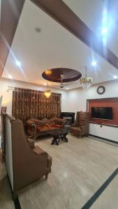 a living room with couches and a flat screen tv at Classy home in Lahore