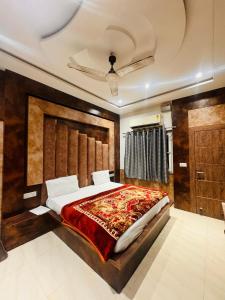 a bedroom with a large bed with a wooden headboard at shyam hotel rexa in Vrindāvan