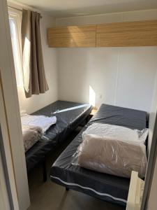 a bedroom with two beds and a window at Camping Carnac in Carnac