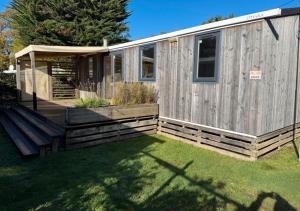 a house with a wooden fence and a yard at Camping Carnac in Carnac