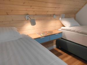 a room with two beds and a table with a book at Harasiuki House in Harasiuki