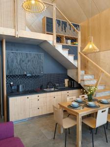 a kitchen and dining room with a table and a staircase at Harasiuki House in Harasiuki