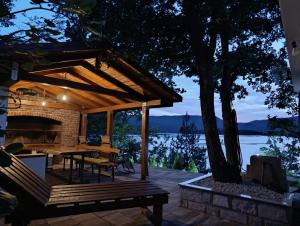 a wooden deck with a table and a fireplace at Apartman Ramljak in Prozor