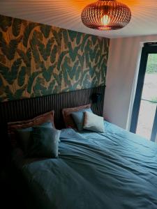 a bedroom with a large bed with a colorful wall at Whispering Pines in Retie