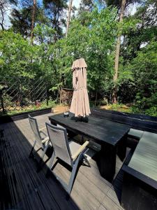 a table and chairs on a wooden deck at Whispering Pines in Retie +11 photos