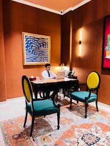 a man sitting at a desk with a laptop at The LC Hotel in Lahore
