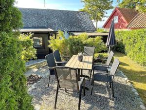 a table and chairs with an umbrella on a patio at 8 person holiday home in Beddingestrand-By Traum in Beddinge Strand +14 photos