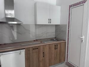 a kitchen with white cabinets and a sink at Olympus Apartments in Paralia Katerinis +35 photos