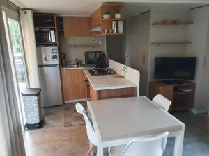 a kitchen with a white table and a white table and chairs at HerGine in Pérols