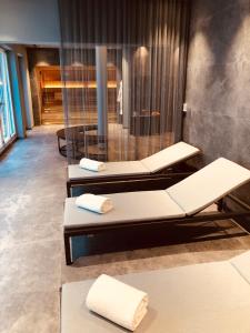 a spa room with three beds and a shower at SOLLER Business Hotel - Munich Airport MUC in Hallbergmoos