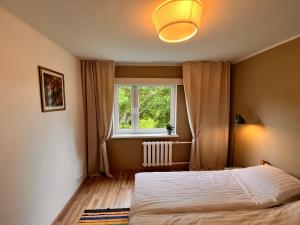 a bedroom with a bed and a window at Leisi Forest View Apartment in Leisi