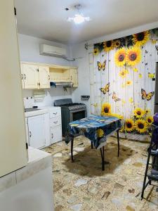 a kitchen with a table with a curtain with sunflowers at Casa céntrica en Paraíso Amplia y cómoda in Paraíso