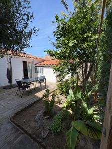 a patio with a table and chairs in a yard at Maisonnette à Arago in Les Sables-d'Olonne
