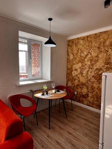 a living room with a table and red chairs at Жк сокол in Kokshetau +2 photos