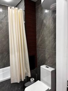 a bathroom with a white toilet and a shower at Жк сокол in Kokshetau